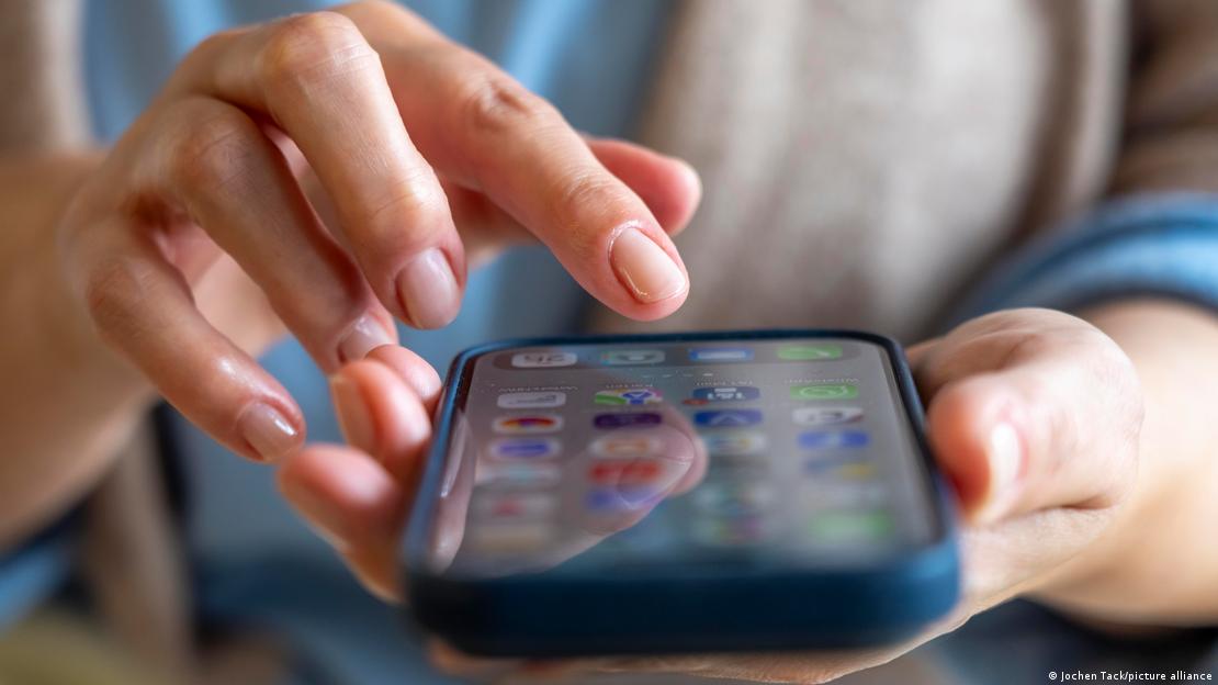 Akıllı telefonunda bir app'e / uygulamaya tıklayan bir kadın