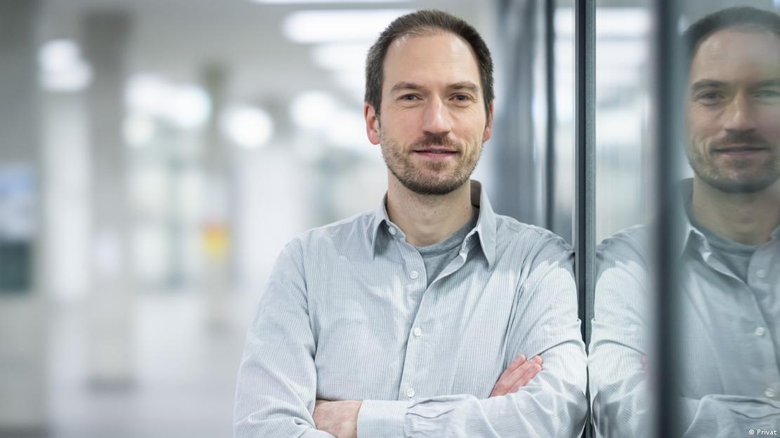 Mann lehnt an Fensterscheibe