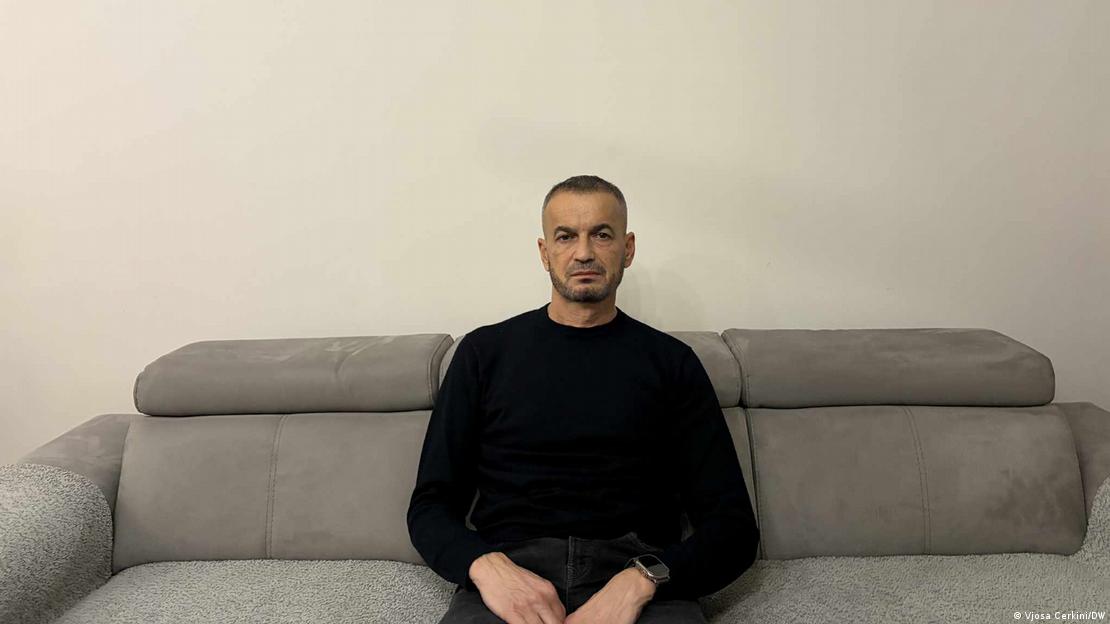 Човек во црн џемпер седи на софа