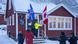 A worker checks a Canadian flag at Ottawa's new consulate in Nuuk, Greenland, before the official opening, as four other individuals look on A worker checks a Canadian flag at Ottawa's new consulate in Nuuk, Greenland, before the official opening, as four other individuals look on