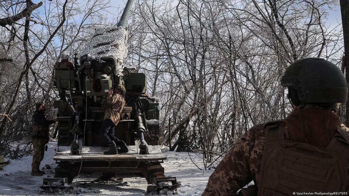 Cuatro soldados ucranianos preparan un obús para disparar tras las ramas desnudas de un árbol cubierto de nieve. Cuatro soldados ucranianos preparan un obús para disparar tras las ramas desnudas de un árbol cubierto de nieve.