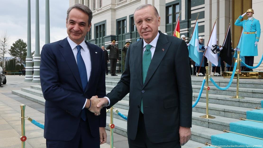 Yunanistan Başbakanı Kiryakos Mitsotakis ile Cumhurbaşkanı Recep Tayyip Erdoğan gülümseyerek tokalaşıyor