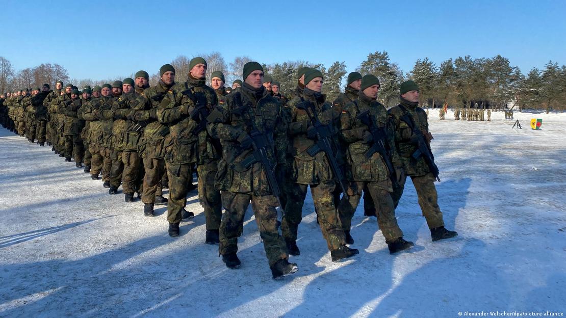 Soldados desfilando en formación en mitad de la nieve.