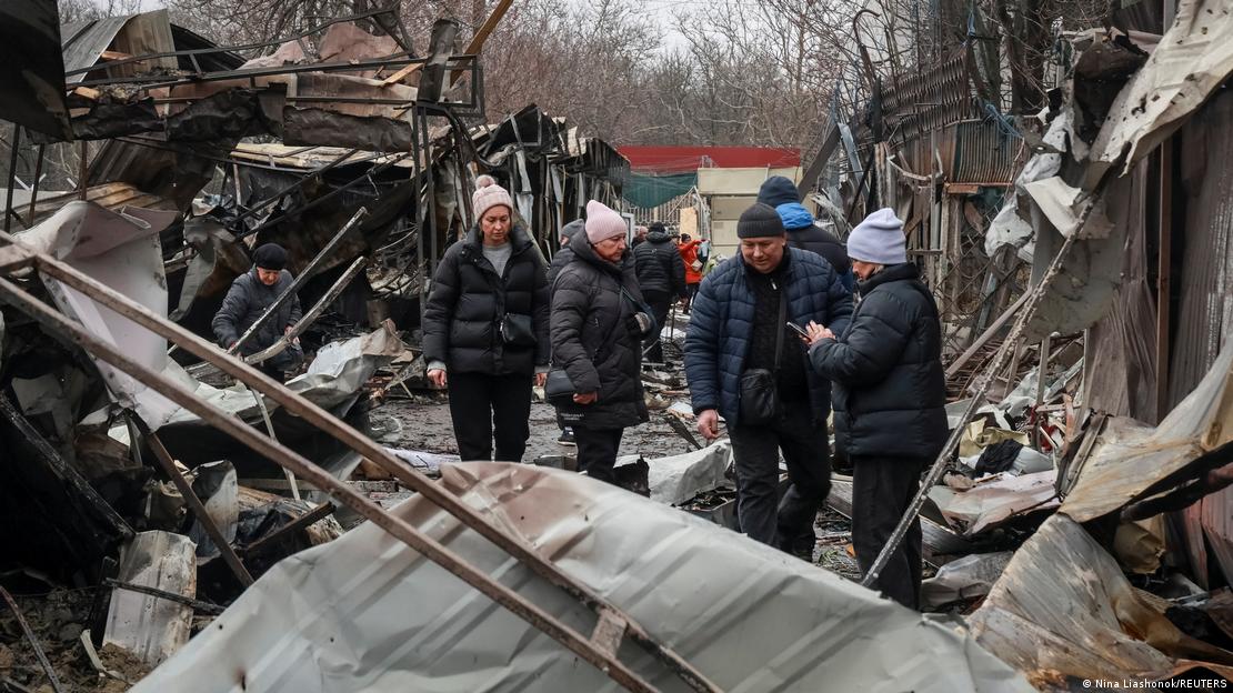 Anwohner in dicken Winterjacken betrachten die Schäden an einem Straßenmarkt nach russischem Drohnenangriff auf Odessa Anwohner in dicken Winterjacken betrachten die Schäden an einem Straßenmarkt nach russischem Drohnenangriff auf Odessa