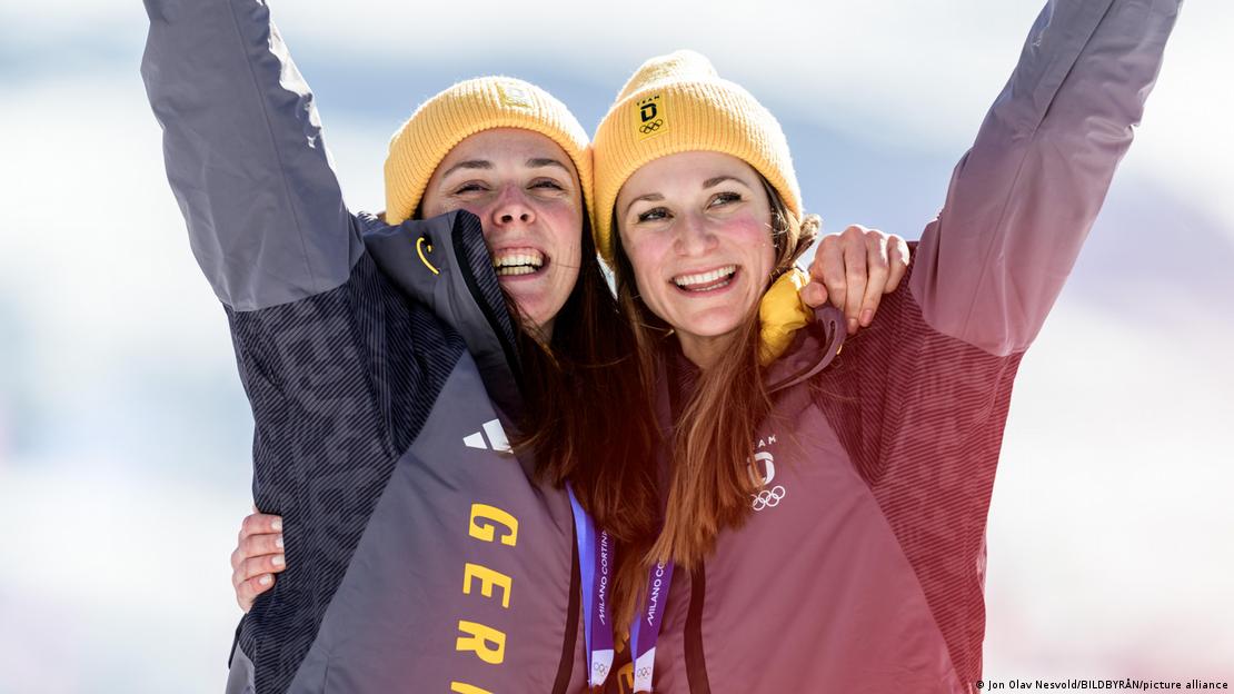 Las alemanas Laura Ginnler y Coletta Rydzek celebraron su medalla de bronce, sin percatarse de la presencia del perro lobo.