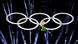 A performer flies through the air in front of the Olympic rings A performer flies through the air in front of the Olympic rings