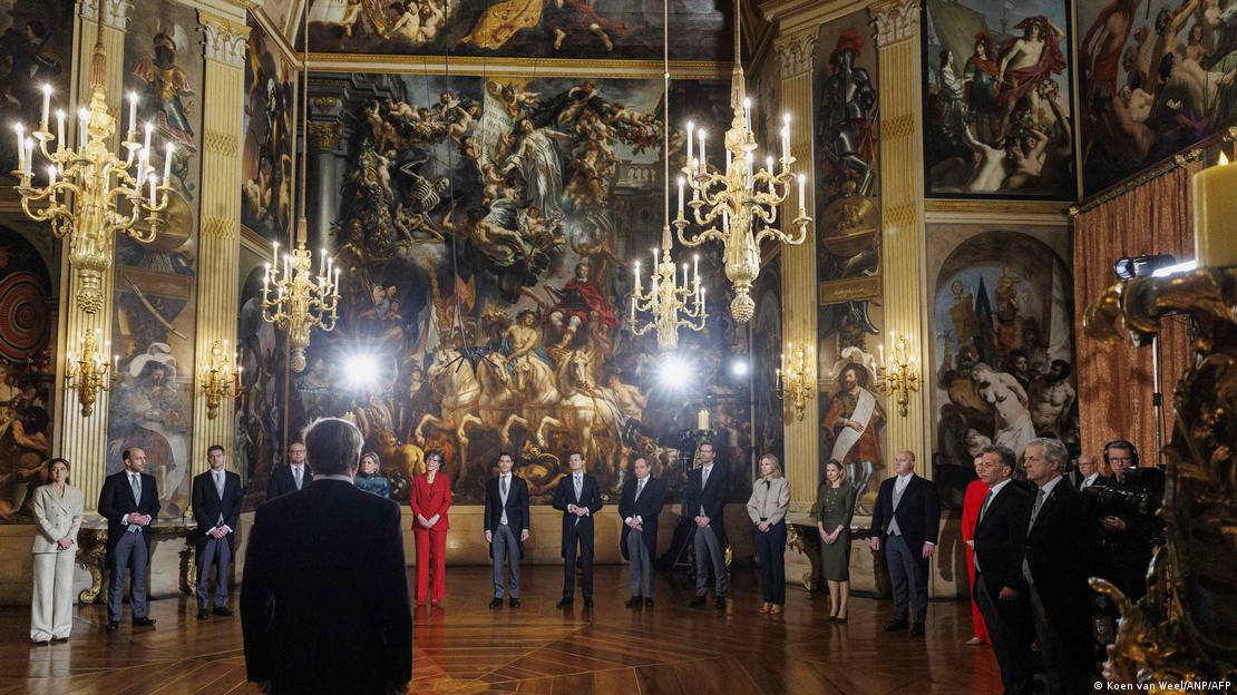 Niederlande Den Haag 2026 | Ein prunkvoller Saal, in dem die neuen Regierungsmitglieder aufgereiht vor Gemälden dem König Willem-Alexander gegenüberstehen, von dem man nur den Rücken sieht (23.02.2026)
