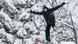 In Nahaufnahme ist ein junger Mann zu sehen, der mit Skiern an den Füßen und mit Skistöcken in der Hand durch die Luft fliegt. In Nahaufnahme ist ein junger Mann zu sehen, der mit Skiern an den Füßen und mit Skistöcken in der Hand durch die Luft fliegt.