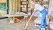 Mujer pasa la aspiradora en su casa, con su perro atrás. Mujer pasa la aspiradora en su casa, con su perro atrás.