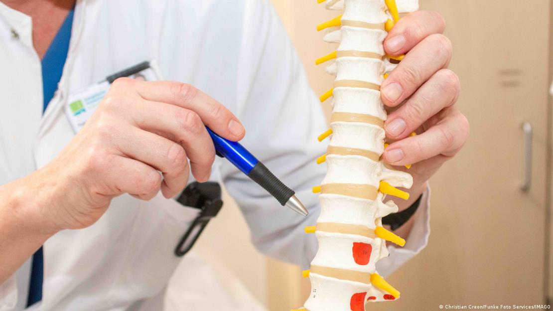 جرمنی میں ایک سرجن اپنے ایک مریض کو اس کی ریڑھ کی ہڈی کے مسئلے کی ایک ماڈل کے ساتھ طبی وضاحت کرتے ہوئے