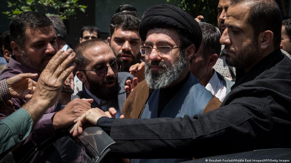 Mojtaba Jamenei, hijo y posible sucesor del ayatolá Alí Jamenei, en imagend e archivo de 2019, rodeado de otros hombres que lo intentan saludar o lo protegen.