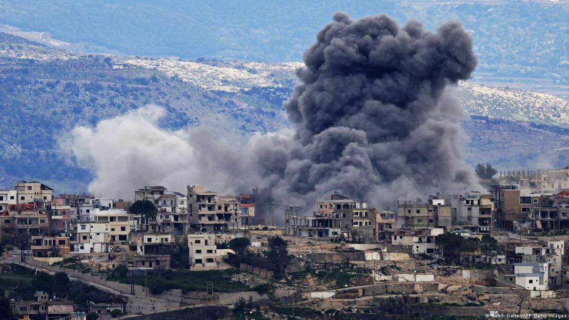 Çok sayıda hasar görmüş binanın olduğu bir yerleşim yerinden yükselen siyah dumanlar