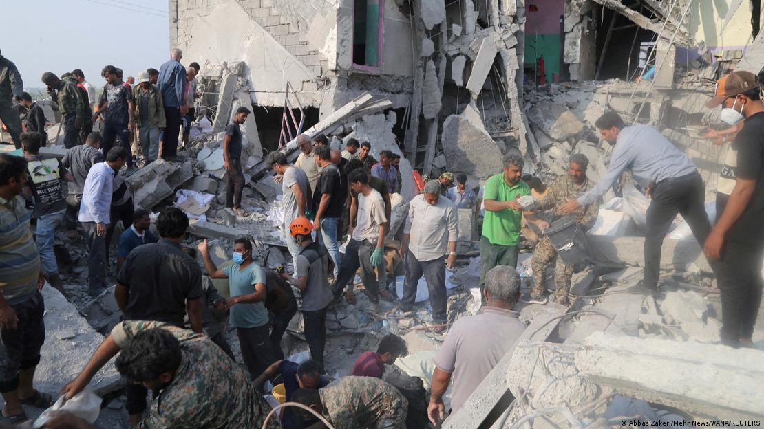 Minab'ta vurulan kız okulunun enkazında arama kurtarma çalışmaları yürüten kalabalık