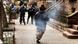A man carrying a device emitting smoke seen running towards police A man carrying a device emitting smoke seen running towards police
