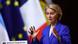 Ursula von der Leyen speaking into a microphone with the EU and French flags behind her Ursula von der Leyen speaking into a microphone with the EU and French flags behind her