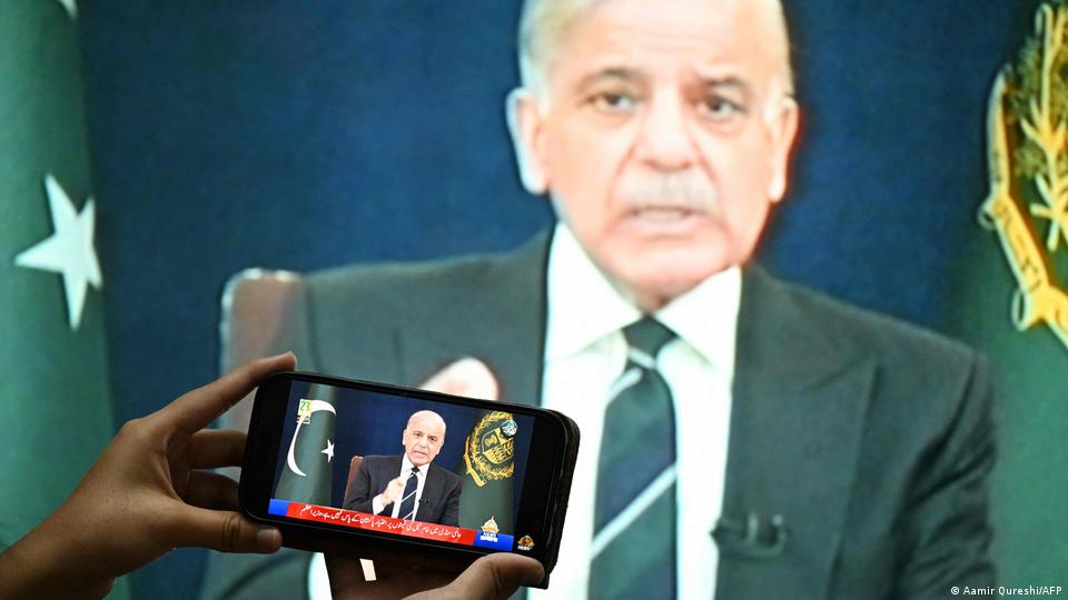 Imagen en pantalla grande y en una pantalla de móvil sobrepuesta en primer plano de Shehbaz Sharif, en un discurso televisado sobre la crisis en Irán (el 9 de marzo de 2026).