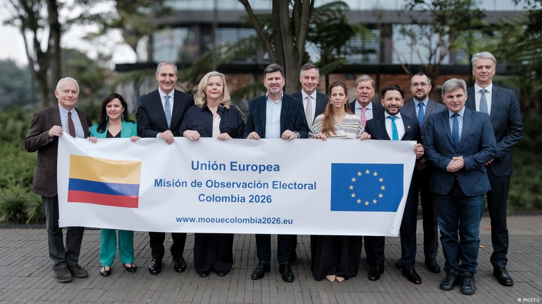 Doce observadores del Parlamento Europeo llegaron el fin de semana de las elecciones legislativas a Colombia (7-8.03.2026). Sostienen una gran pancarta que los identifica como integrantes de la Misión de Observación Electoral de la UE.
