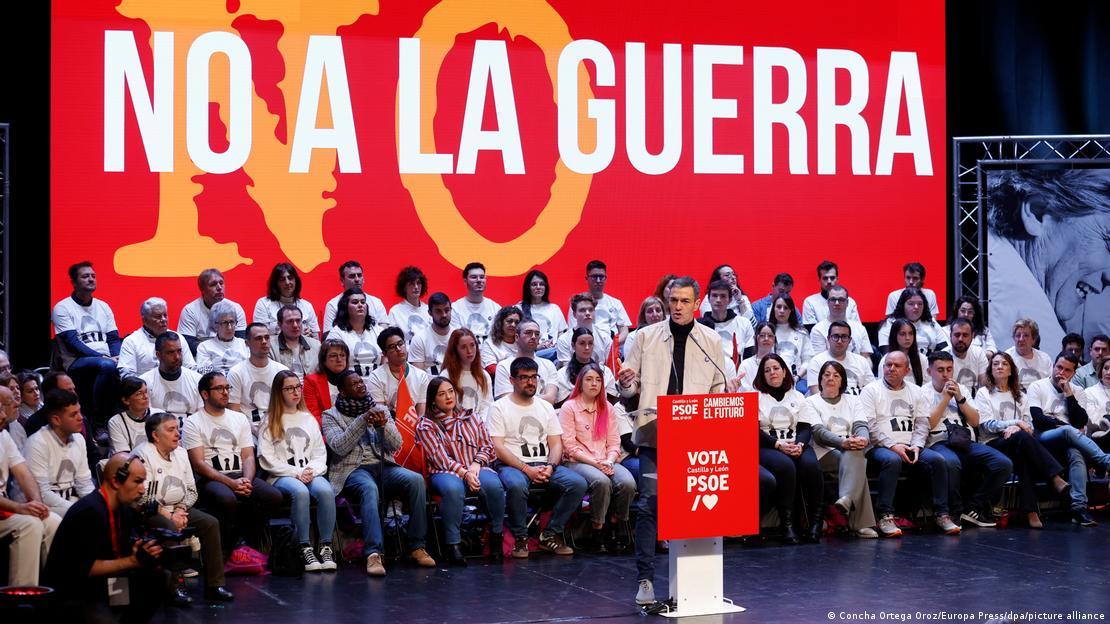 Kryeministri spanjoll Pedro Sánchez duke folur në një miting, pas tij qëndron sllogani "Jo luftës" Kryeministri spanjoll Pedro Sánchez duke folur në një miting, pas tij qëndron sllogani "Jo luftës"