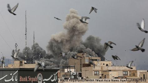 Pájaros evantan vuelo, mientras el humo se eleva, tras una explosión, después de que Israel y Estados Unidos lanzaron ataques contra Irán.