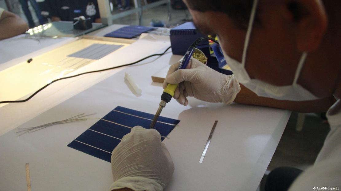 Jovem trabalha na construção de placas solares