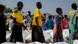 Women walk to their allotted bags of maize grain as field staff monitor and direct the distribution at a food distribution center Women walk to their allotted bags of maize grain as field staff monitor and direct the distribution at a food distribution center