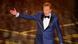 Picture of US talk show host, Conan O'Brien, in dark blue tuxedo with his one arm extended. Picture of US talk show host, Conan O'Brien, in dark blue tuxedo with his one arm extended.