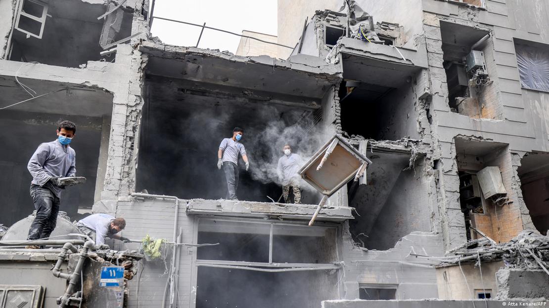 Tahran'ı hedef alan saldırı sonrasında enkazı temizleyen İranlılar.