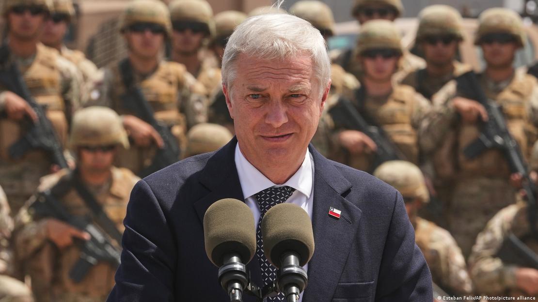 José Antonio Kast mira hacia la cámara mientras de fondo, desenfocados, se ven soldados del Ejército de Chile.