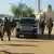 Des soldats armés entourent le cortège du général Abdourahamane Tiani qui arrive à une célébration du Ramadan, le jeudi 19 mars 2026 à Niamey