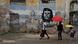 Un grupo de personas camina ante una imagen del Che Guevara en La Habana. Un grupo de personas camina ante una imagen del Che Guevara en La Habana.