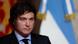 Primer plano de rostro de Javier Milei, presidente de Argentina. Detrás, bandera argentina.