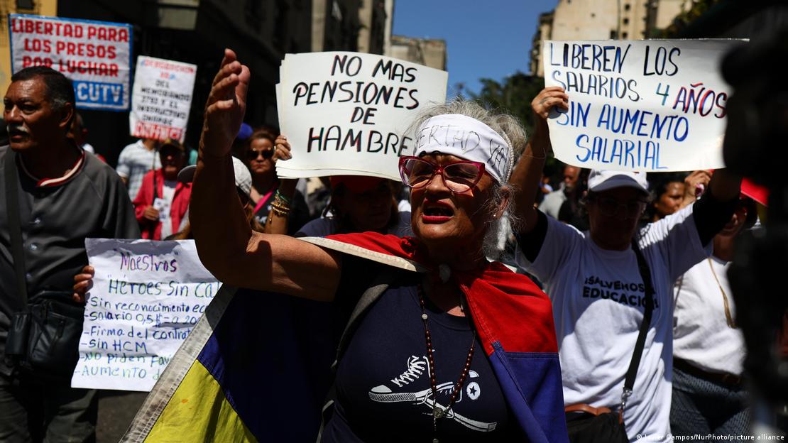 Manifestantes em Caracas protestam contra os baixos salários e a pobreza no país, com cartazes com frases de protesto
