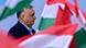 Mid-shot of Viktor Orban in profile, facing right, surrounded by waving red, white and green Hungarian flags Mid-shot of Viktor Orban in profile, facing right, surrounded by waving red, white and green Hungarian flags