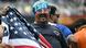 A US fan holds up a US flag while wearing a football-shaped hat and eyeglasses painted in US colors (July 2025) A US fan holds up a US flag while wearing a football-shaped hat and eyeglasses painted in US colors (July 2025)