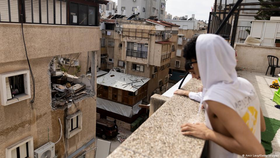 Un israelí mira desde el tejado de una vivienda en Bnei Brak los destrozos ocasionados por un misil iraní en el edificio de enfrente.