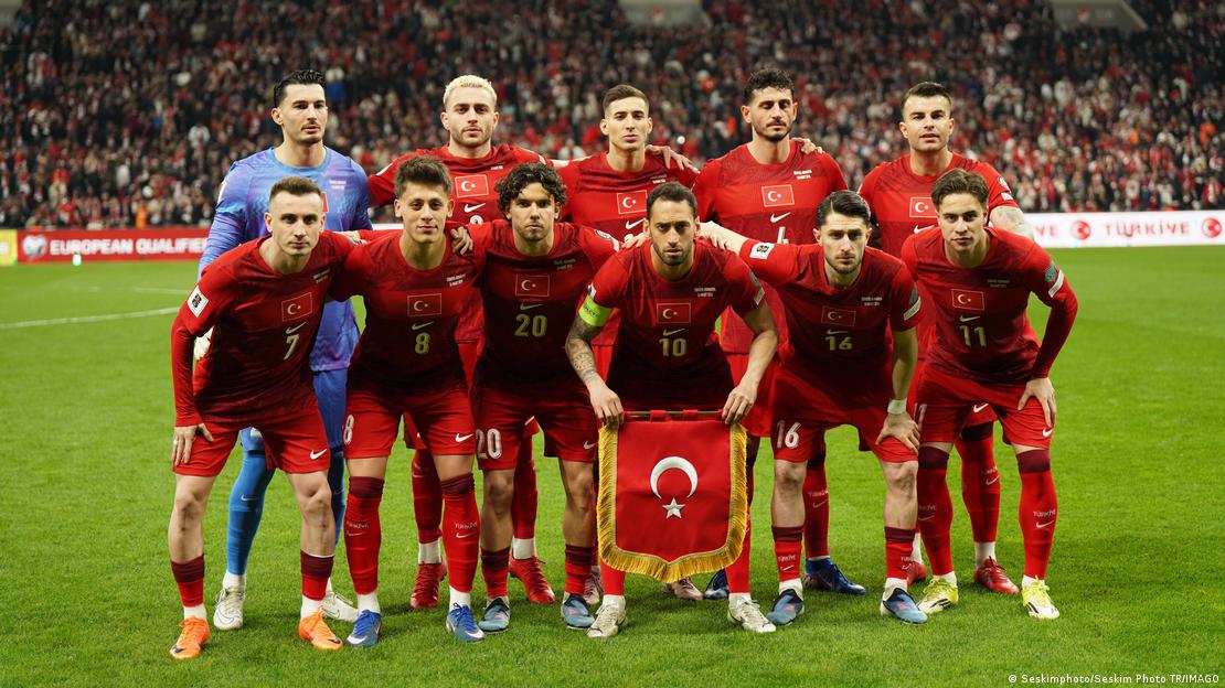 Türkiye'nin 2026 Dünya Kupası Avrupa Elemeleri play-off turu finalinde Romanya'ya karşı sahaya çıkan ilk 11'i, maç öncesi Türk bayrağı ile takım fotoğrafı çektiriyor.