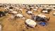 Vista aérea de un gran campamento de refugiados con tiendas blancas de ACNUR y refugios temporales en un paisaje seco y polvoriento. Personas se reúnen entre las tiendas y se observan suministros de ayuda, lo que simboliza la ayuda humanitaria, el desplazamiento y la asistencia internacional en regiones en crisis. Vista aérea de un gran campamento de refugiados con tiendas blancas de ACNUR y refugios temporales en un paisaje seco y polvoriento. Personas se reúnen entre las tiendas y se observan suministros de ayuda, lo que simboliza la ayuda humanitaria, el desplazamiento y la asistencia internacional en regiones en crisis.