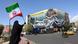 A woman waves an Iranian flag near a sign in central Tehran reads 'The Strait of Hormuz remains closed' A woman waves an Iranian flag near a sign in central Tehran reads 'The Strait of Hormuz remains closed'