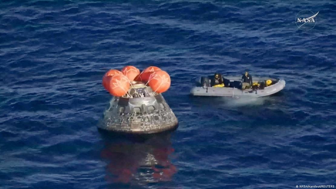 Cápsula Onion no oceano, com bote de resgate se aproximando