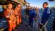 The Artemis crew wearing orange suits and NASA staff wearing blue suits The Artemis crew wearing orange suits and NASA staff wearing blue suits