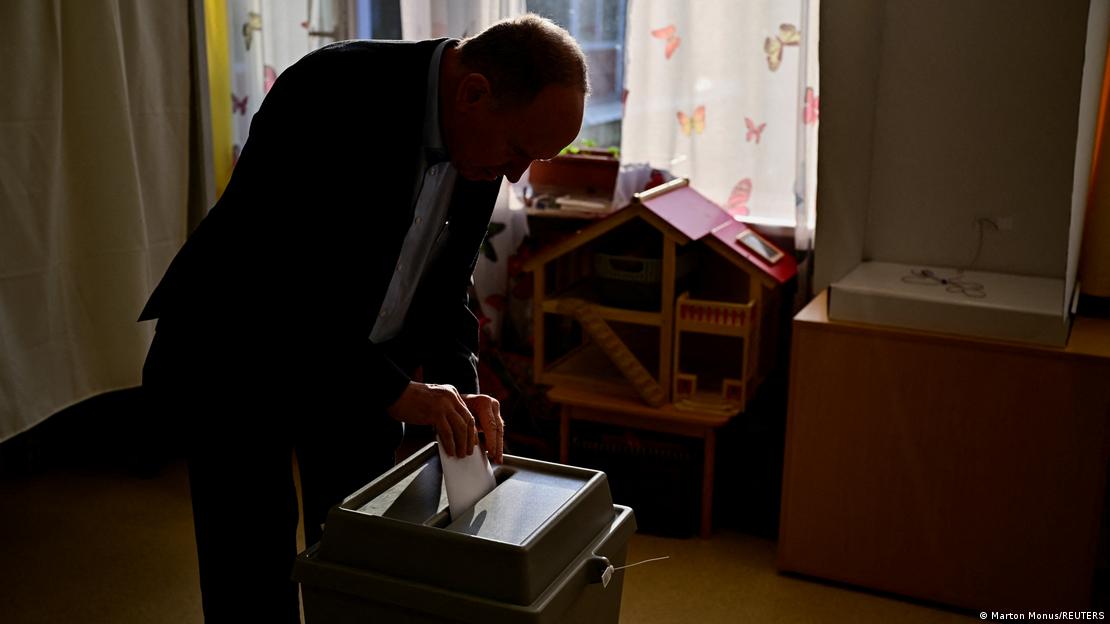 Elindeki pusulayı oy sandığına atan bir adam