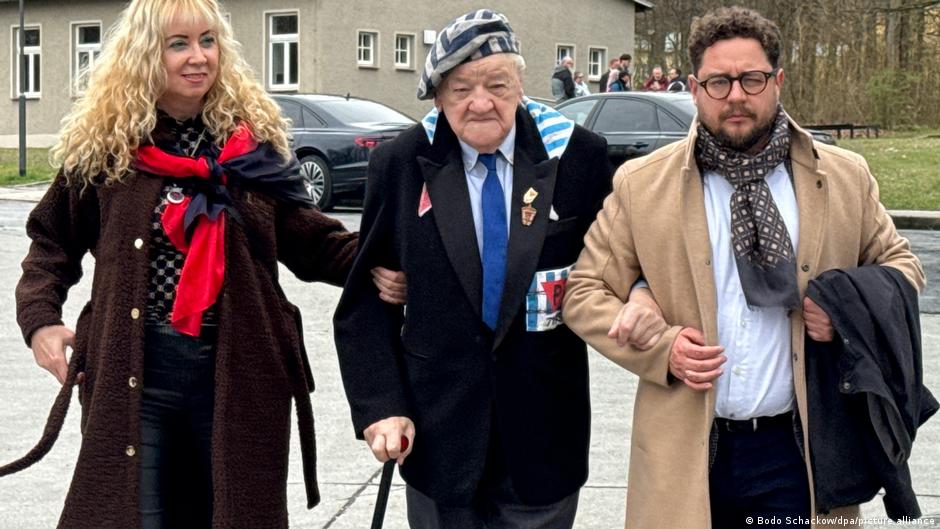 Alojzi Macijak (98) iz Poljske, jedan od dvojice preživelih zarobljenika koncentracionog logora Buhenvald, sa dvoje pratilaca koji ga pridržavaju