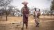 Sudan Nuba-Berge | Bürgerkrieg | Frauen tragen Getreidesäcke durch Vertriebenenlager in den Nuba-Bergen Sudan Nuba-Berge | Bürgerkrieg | Frauen tragen Getreidesäcke durch Vertriebenenlager in den Nuba-Bergen