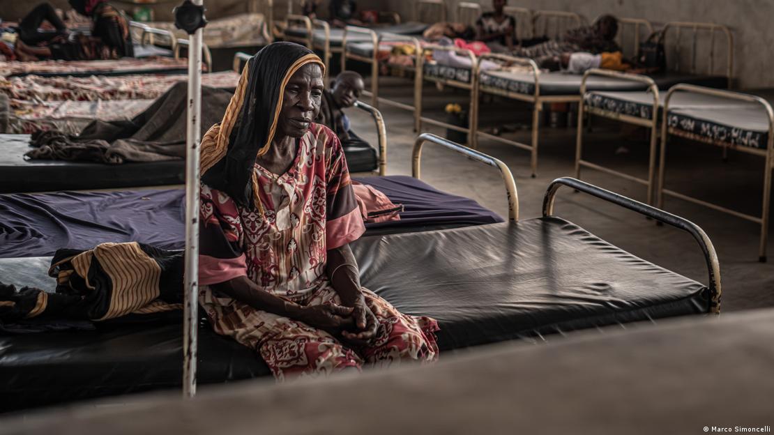 Mulher sentada em um dos leitos do hospital