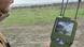 La foto muestra la barbilla de un soldado en un campo, sosteniendo una pantalla en la mano y observando la interceptación de un dron.
