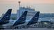 The tails of three Lufthansa planes seen on the tarmac at Frankfurt International Airport under a slightly red morning sky The tails of three Lufthansa planes seen on the tarmac at Frankfurt International Airport under a slightly red morning sky