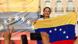 La líder opositora venezolana sostiene sonriente una bandera de su país mientras el público la aclama y la graba con sus celulares. La líder opositora venezolana sostiene sonriente una bandera de su país mientras el público la aclama y la graba con sus celulares.