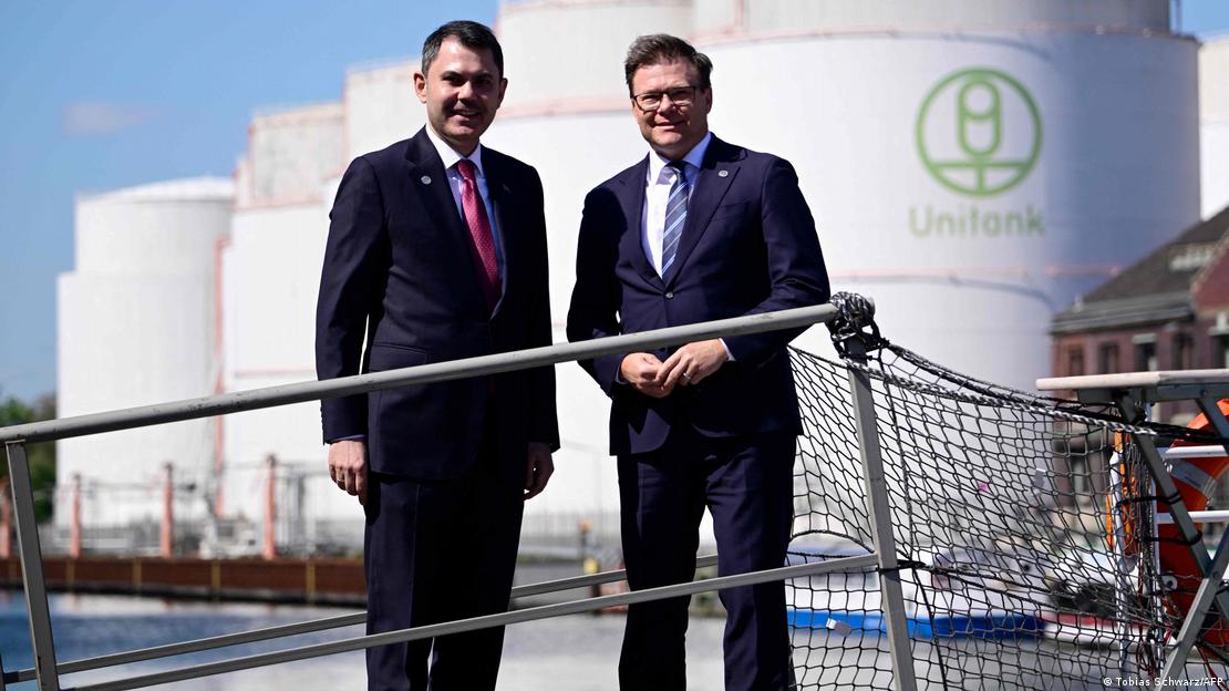 Das Bild zeigt Deutschlands Umweltminister Carsten Schneider (rechts) und seinen türkischen Kollegen Murat Kurum im alten Westhafen in Berlin, im Hintergrund sind vier große Silos zu erkennen