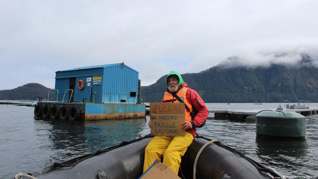 El activista Peter Hartmann en el Parque Nacional Laguna San Rafael, Chile, sosteniendo un cartel.