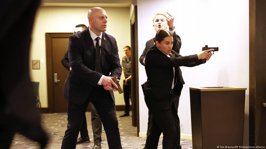 Saldırı anında ellerinde tabancayla otel koridorunda görülen Gizli Servis ajanları. Kadın ajan tabancasını ileri doğru doğrultmuş.